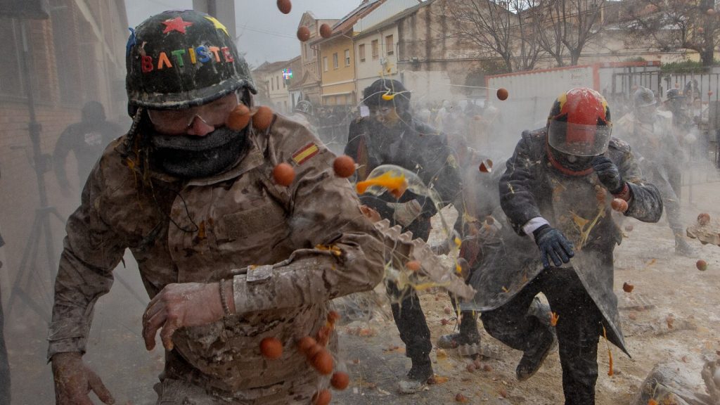 Photos show flour, eggs and firecrackers flying at Spain’s Els Enfarinats festival